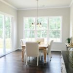 Large kitchen in new homes by Niblock homes with white cabinetry, dark hardwood floors, and kithchen island with sink.